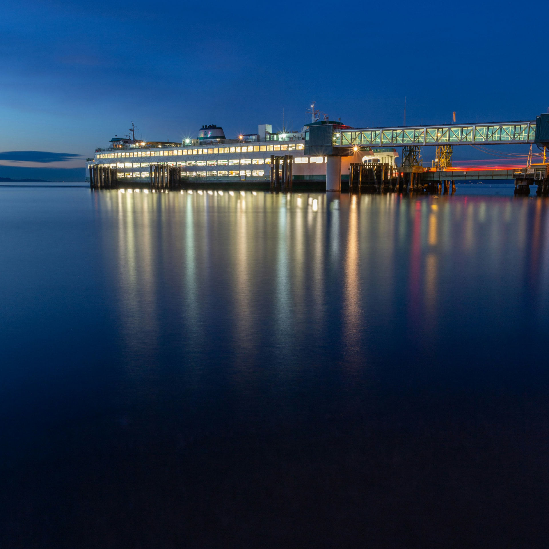 The Edmonds ferry terminal lit up at dusk with reflections on Puget Sound